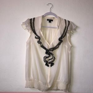 Off-white blouse with black lacy ruffles V-neck.